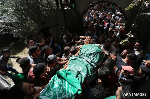 Mourners carry the body of Palestinian Muntaser al-Baz, who was shot dead by Israeli forces during a protest at the Israel-Gaza border, during his funeral in Dair Al Balah in the central Gaza Strip, on October 24, 2018....