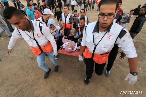A wounded Palestinian paramedic is evacuated during clashes with Israeli troops in tents protest where Palestinians demand the right to return to their homeland at the Israel-Gaza border, in al-Bureij in the center of Ga...