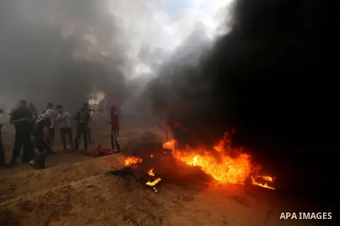 Palestinian protesters gather during clashes with Israeli troops in tents protest where Palestinians demand the right to return to their homeland at the Israel-Gaza border, in Khan Youins in the southern Gaza Strip on Oc...