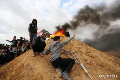 Palestinian protesters gather during clashes with Israeli troops in tents protest where Palestinians demand the right to return to their homeland at the Israel-Gaza border, in Khan Youins in the southern Gaza Strip on Oc...