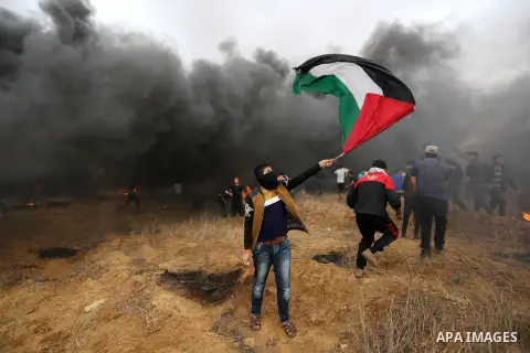 Palestinian protesters gather during clashes with Israeli troops in tents protest where Palestinians demand the right to return to their homeland at the Israel-Gaza border, in Khan Youins in the southern Gaza Strip on Oc...