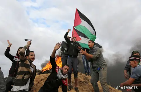 Palestinian protesters gather during clashes with Israeli troops in tents protest where Palestinians demand the right to return to their homeland at the Israel-Gaza border, in Khan Youins in the southern Gaza Strip on Oc...