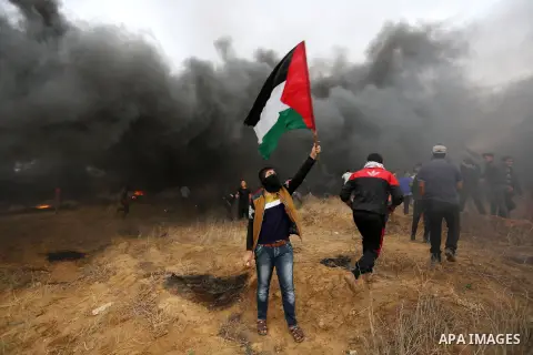 Palestinian protesters gather during clashes with Israeli troops in tents protest where Palestinians demand the right to return to their homeland at the Israel-Gaza border, in Khan Youins in the southern Gaza Strip on Oc...