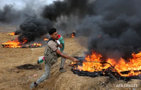 Palestinian protesters gather during clashes with Israeli troops in tents protest where Palestinians demand the right to return to their homeland at the Israel-Gaza border, in Khan Youins in the southern Gaza Strip on Oc...