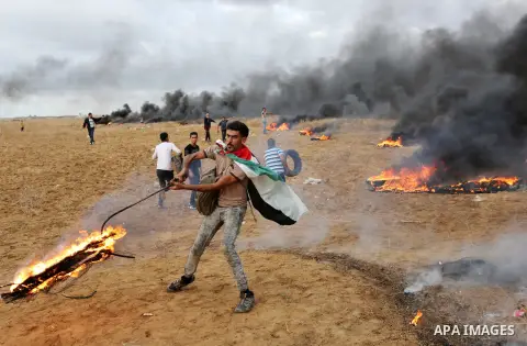 Palestinian protesters gather during clashes with Israeli troops in tents protest where Palestinians demand the right to return to their homeland at the Israel-Gaza border, in Khan Youins in the southern Gaza Strip on Oc...
