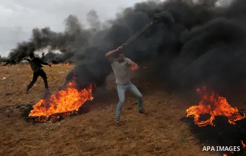Palestinian protesters gather during clashes with Israeli troops in tents protest where Palestinians demand the right to return to their homeland at the Israel-Gaza border, in Khan Youins in the southern Gaza Strip on Oc...