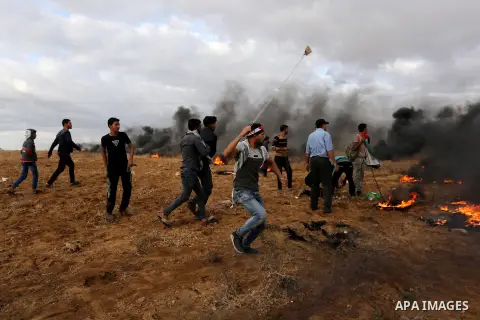Palestinian protesters gather during clashes with Israeli troops in tents protest where Palestinians demand the right to return to their homeland at the Israel-Gaza border, in Khan Youins in the southern Gaza Strip on Oc...