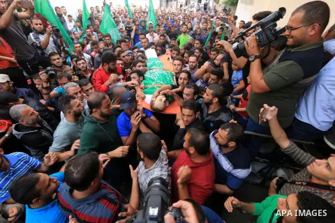 Mourners carry the body of Palestinian Mujahid Aql, 24, who was died of his wounds which he sustained by Israeli forces during clashes in tents protest where Palestinians demand the right to return to their homeland at t...