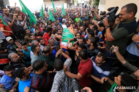 Mourners carry the body of Palestinian Mujahid Aql, 24, who was died of his wounds which he sustained by Israeli forces during clashes in tents protest where Palestinians demand the right to return to their homeland at t...