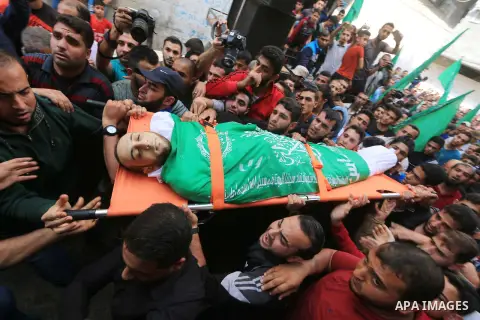 Mourners carry the body of Palestinian Mujahid Aql, 24, who was died of his wounds which he sustained by Israeli forces during clashes in tents protest where Palestinians demand the right to return to their homeland at t...