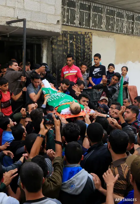 Mourners carry the body of Palestinian Mujahid Aql, 24, who was died of his wounds which he sustained by Israeli forces during clashes in tents protest where Palestinians demand the right to return to their homeland at t...