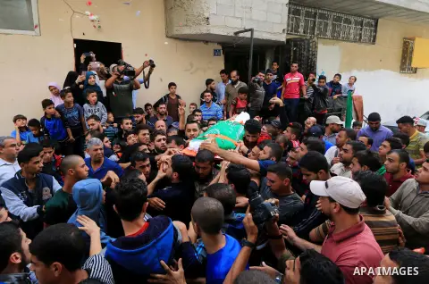 Mourners carry the body of Palestinian Mujahid Aql, 24, who was died of his wounds which he sustained by Israeli forces during clashes in tents protest where Palestinians demand the right to return to their homeland at t...