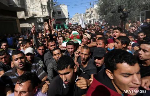 Mourners carry the body of Palestinian Ahmed Abu Lebda, 22, who was shot dead by Israeli forces during clashes in tents protest where Palestinians demand the right to return to their homeland at the Israel-Gaza border, d...