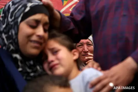 Relatives of Palestinian Othman Ladadwah, who was shot dead by Israeli forces during clashes the day before, mourn during his funeral in the village of Al-Mazraa Al-Gharbeya, in the West Bank city of Ramallah on October...
