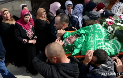 Mourners carry the body of Palestinian Othman Ladadwah, who was shot dead by Israeli forces during clashes the day before, during his funeral in the village of Al-Mazraa Al-Gharbeya, in the West Bank city of Ramallah on...