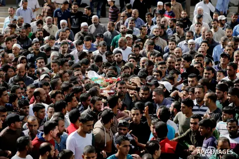 Mourners carry the body of Palestinian Ahmed Abu Lebda, 22, who was shot dead by Israeli forces during clashes in tents protest where Palestinians demand the right to return to their homeland at the Israel-Gaza border, d...