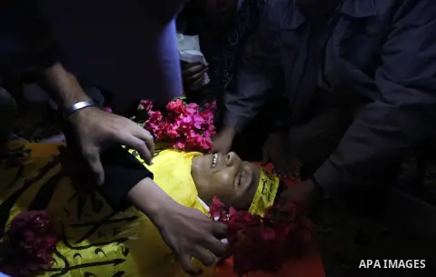 Relatives of Palestinian Yahya el-Hassanat, 37, who was shot dead by Israeli troops during clashes in tents protest where Palestinian demand rights to return to their homeland at Israel-Gaza border, mourn over his body d...