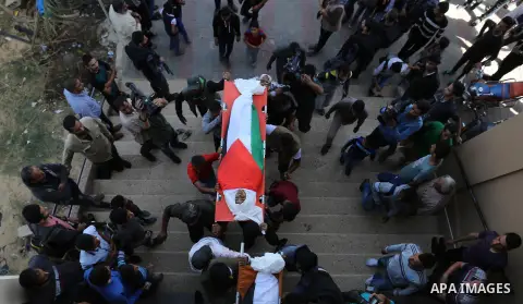 Palestinian mourners carry the bodies of three Palestinian teenagers who were killed in an Israeli air strike on the Gaza Strip during their funeral in Deir el-Balah in central of the Gaza Strip on October 29, 2018. Phot...