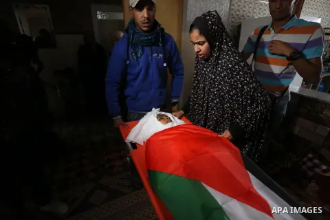 Relatives of Palestinian teenager Khaled Saed, who was killed in an Israeli air strike on the Gaza Strip , mourn over his body during his funeral in Deir el-Balah in central of the Gaza Strip on October 29, 2018. Photo b...