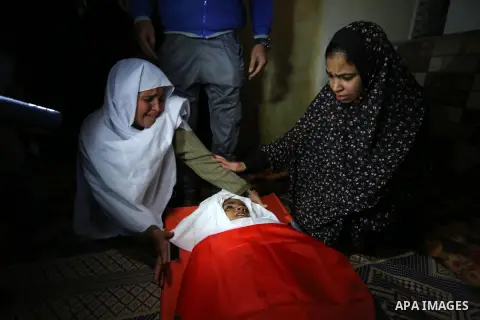 Relatives of Palestinian teenager Khaled Saed, who was killed in an Israeli air strike on the Gaza Strip , mourn over his body during his funeral in Deir el-Balah in central of the Gaza Strip on October 29, 2018. Photo b...