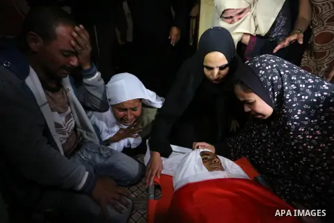 Relatives of Palestinian teenager Khaled Saed, who was killed in an Israeli air strike on the Gaza Strip , mourn over his body during his funeral in Deir el-Balah in central of the Gaza Strip on October 29, 2018. Photo b...