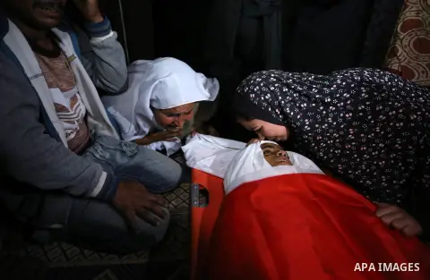 Relatives of Palestinian teenager Khaled Saed, who was killed in an Israeli air strike on the Gaza Strip , mourn over his body during his funeral in Deir el-Balah in central of the Gaza Strip on October 29, 2018. Photo b...