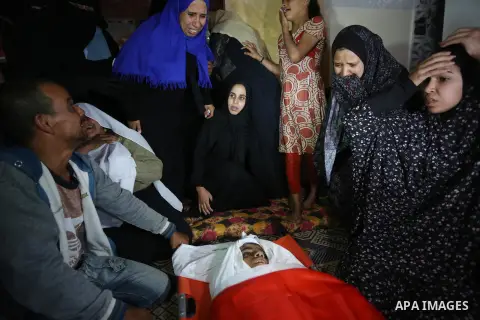 Relatives of Palestinian teenager Khaled Saed, who was killed in an Israeli air strike on the Gaza Strip , mourn over his body during his funeral in Deir el-Balah in central of the Gaza Strip on October 29, 2018. Photo b...