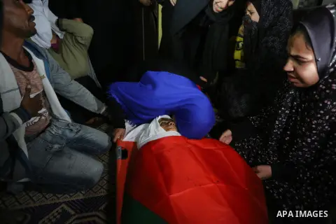 Relatives of Palestinian teenager Khaled Saed, who was killed in an Israeli air strike on the Gaza Strip , mourn over his body during his funeral in Deir el-Balah in central of the Gaza Strip on October 29, 2018. Photo b...