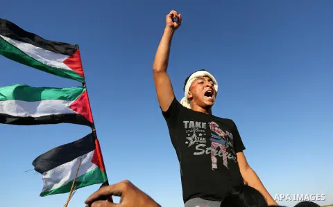 Palestinian protesters gather during clashes with Israeli troops in tents protest where Palestinians demand the right to return to their homeland at the Israel-Gaza border, in Khan Younis in the southern Gaza Strip on No...