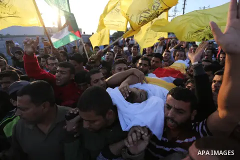 Palestinian Mourners carry the body of Ahmed Al Najar, 21, into his family house during his funeral in Khan Younis in the southern Gaza Strip, Thursday, Nov. 8, 2018. Photo by Ashraf Amra