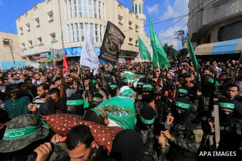 Palestinian militants of the Islamist movement Hamas' military wing Al-Qassam Brigades, carry bodies of Mustafa Abu Odeh and Mahmoud Atallah, two of the seven Palestinians killed during an Israeli special forces operatio...