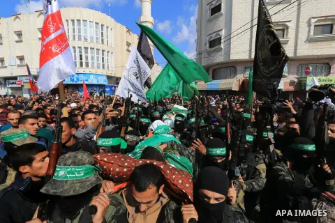Palestinian militants of the Islamist movement Hamas' military wing Al-Qassam Brigades, carry bodies of Mustafa Abu Odeh and Mahmoud Atallah, two of the seven Palestinians killed during an Israeli special forces operatio...