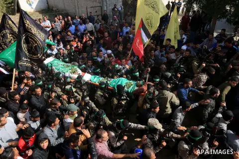 Palestinian militants of the Islamist movement Hamas' military wing Al-Qassam Brigades, carry bodies of Mustafa Abu Odeh and Mahmoud Atallah, two of the seven Palestinians killed during an Israeli special forces operatio...
