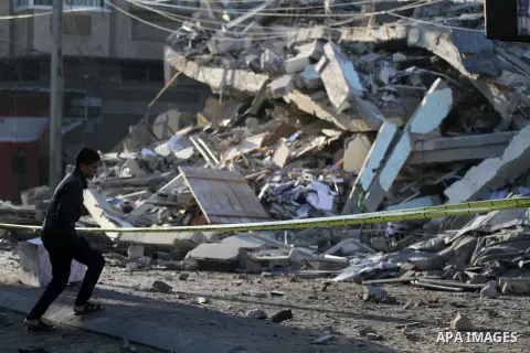 Palestinians look at the rubble of a building in Gaza City on November 13, 2018, after an Israeli air strike. Renewed violence in Gaza threatened to thwart efforts to end months of unrest as Israeli air strikes killed fo...
