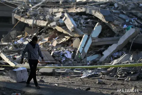 Palestinians look at the rubble of a building in Gaza City on November 13, 2018, after an Israeli air strike. Renewed violence in Gaza threatened to thwart efforts to end months of unrest as Israeli air strikes killed fo...