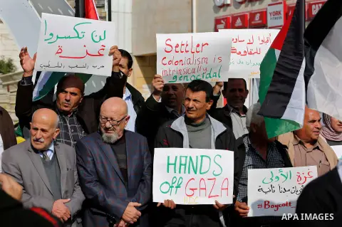 Palestinian protesters hold placards and national flags during a a rally to show solidarity with Palestinians in Gaza, in the West Bank city of Hebron on November 13, 2018. Photo by Wisam Hashlamoun