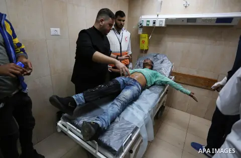 A Palestinian protester who was wounded by Israeli forces during tents protest where Palestinians demand the right to return to their homeland at the Israel-Gaza border, recives treatment at a hospital in Deir al-Balah i...