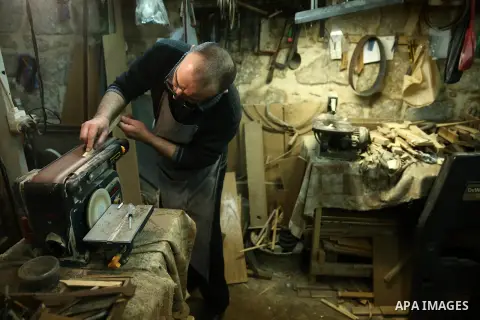 Palestinian nurse, Ali Hassanin, 57, who makes lutes, known in Arabic as an "Oud", works on a musical instrument, at his workshop, in the West Bank city of Nablus on November 26, 2018. Photo by Shadi Jarar'ah