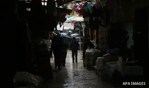 Palestinians walk in a flooded street during a rainy day in the Old City of the West Bank city of Nablus, on December 8, 2018. Photo by Shadi Jarar'ah