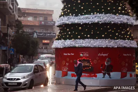 Palestinians walk in a flooded street during a rainy day in the West Bank city of Ramallah, on December 8, 2018. Photo by Ahmad Arouri