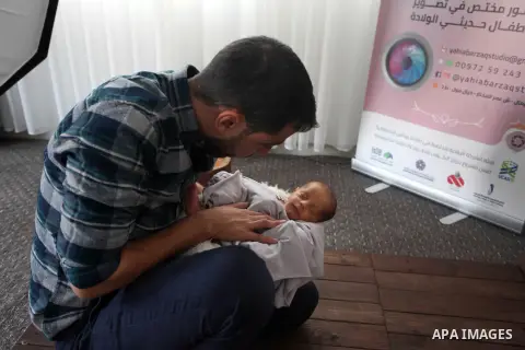 Yahya Barzaq, 28, a Palestinian photographer prepares a new born baby for a photograph during a photo session at his studio in Gaza city, December 17, 2018. Photo by Mahmoud Ajjour