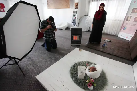 Yahya Barzaq, 28, a Palestinian photographer takes a photo during a new born baby photo session at his studio in Gaza city, December 17, 2018. Photo by Mahmoud Ajjour