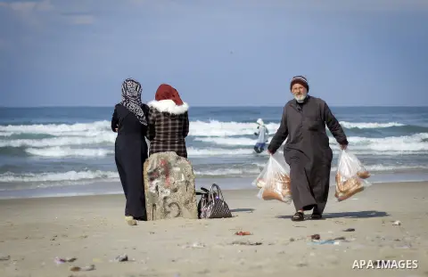 An elderly Palestinian man sells breads on the beach of Gaza city, on December 31, 2018. Photo by Mohammad Abu El-Sebah