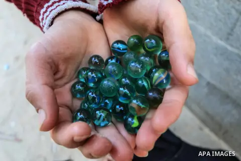 Palestinian children play marbles in a street in Deir al-Balah in the centeral Gaza strip on January 08, 2019. Photo by Mahmoud Khattab