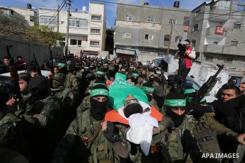 Palestinian militants of the Islamist movement Hamas' military wing Al-Qassam Brigades carry the body of their comrade Mahmoud al-Nabaheen during his funeral in al-Bureij in the central of Gaza Strip, on January 23, 2019...