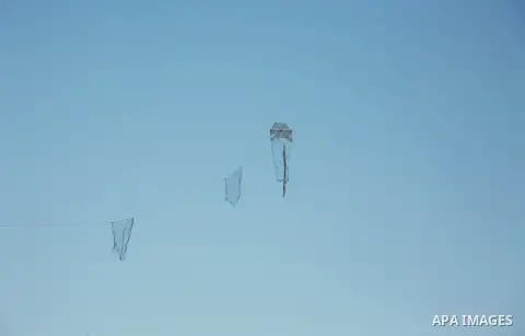 A kite flies over Palestinian protester during clashes with Israeli troops following the tents protest where Palestinians demand the right to return to their homeland at the Israel-Gaza border, in the east of Gaza city,...