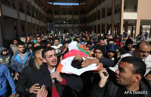 Mourners carry the body of Palestinian Hassan Shalabi, 14, during his funeral at his school in Khan Yunis in the southern Gaza Strip, on February 9, 2019. Two Palestinian teenagers were killed by Israeli fire yesterday,...