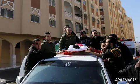 Mourners carry the body of Palestinian Hassan Shalabi, 14, during his funeral at his school in Khan Yunis in the southern Gaza Strip, on February 9, 2019. Two Palestinian teenagers were killed by Israeli fire yesterday,...
