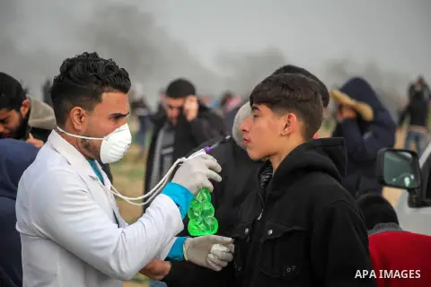 A paramedic treats a Palestinian protester suffers from tear gas fired by Israeli troops during clashes in tents protest where Palestinians demand the right to return to their homeland at the Israel-Gaza border, in Jabal...