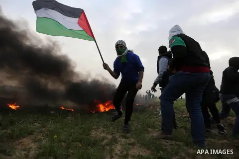 Palestinian protesters gather during clashes with Israeli troops in tents protest where Palestinians demand the right to return to their homeland at the Israel-Gaza border, in Khan Younis in the southern Gaza Strip, on F...